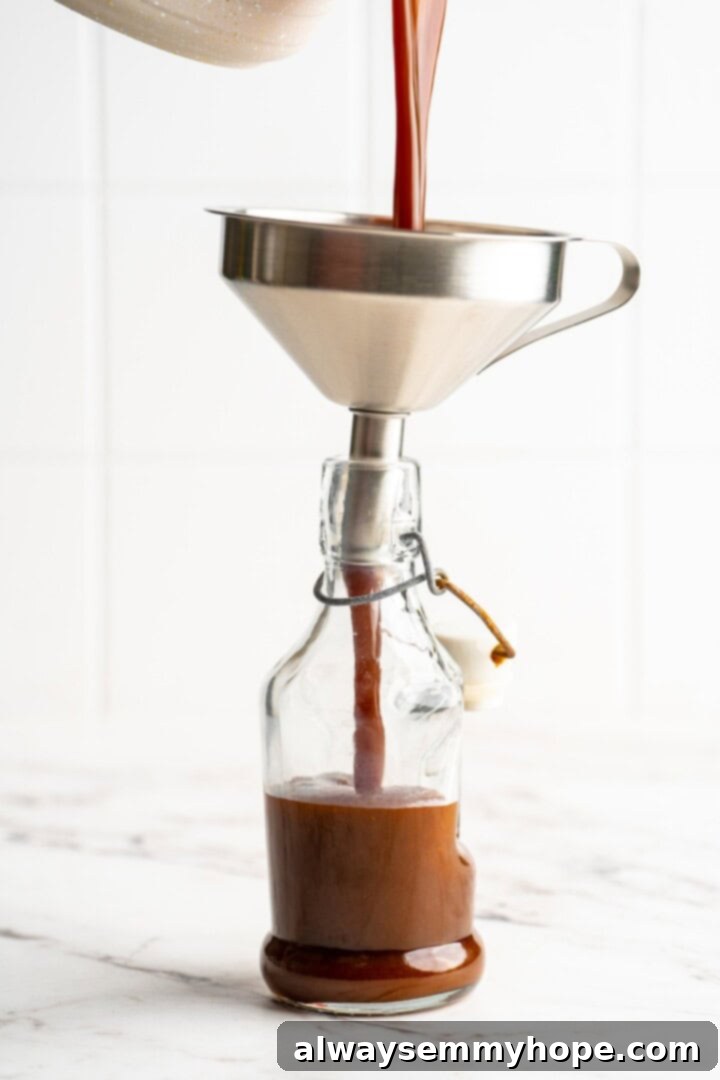 Step 3: Finishing and Storing Your Pumpkin Spice Syrup Pouring freshly made pumpkin spice syrup into a glass jar for storage