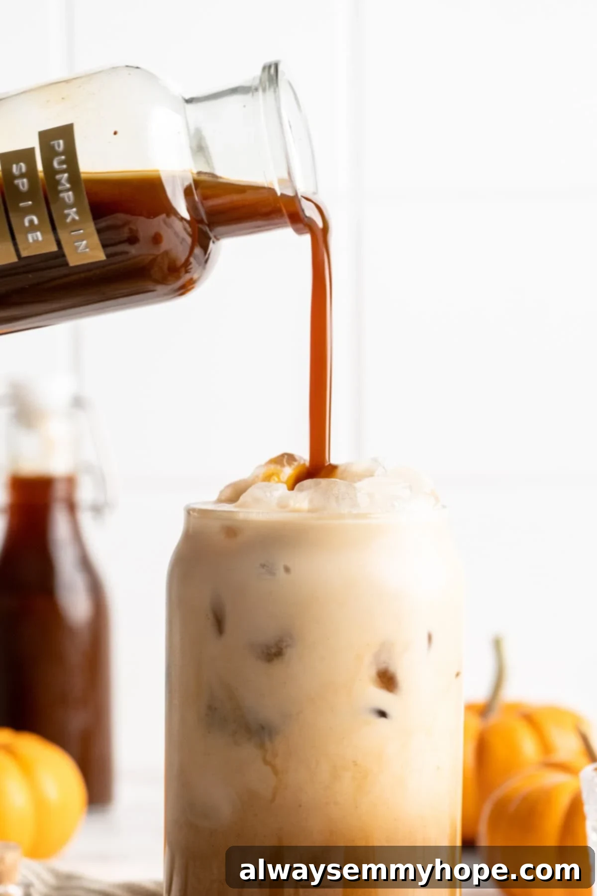 Enjoying Your Homemade Pumpkin Spice Latte Pouring homemade pumpkin spice syrup into a frothy latte in a glass mug