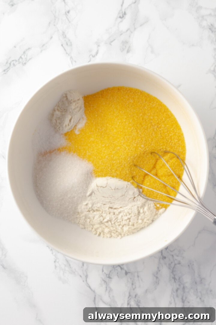 This vegan corn pone is crispy on the outside, tender on the inside, and so delicious! If you like cornbread, you’ll love this recipe. Dry ingredients for corn pone in a mixing bowl before whisking