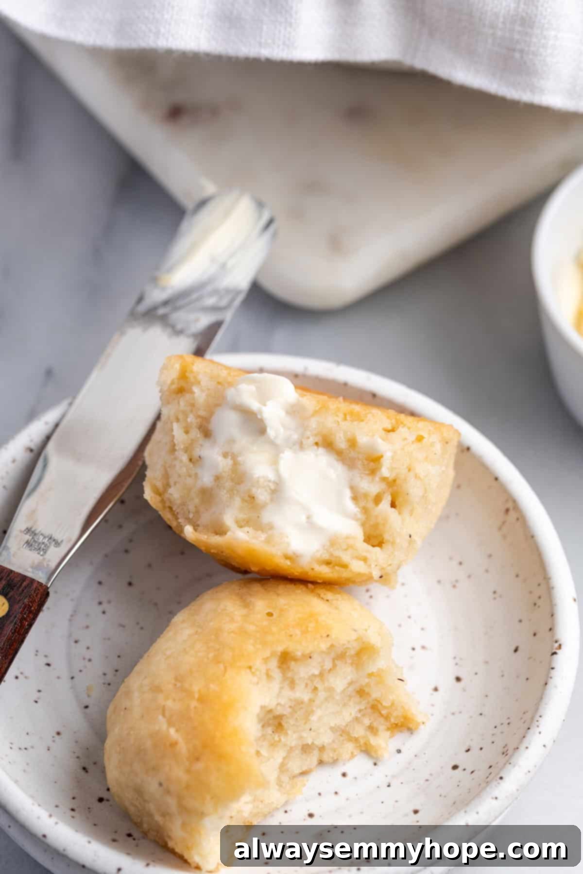 Delicious Gluten-Free Vegan Dinner Rolls with Butter A plate of golden-brown vegan gluten-free dinner rolls with a pat of butter melting on top