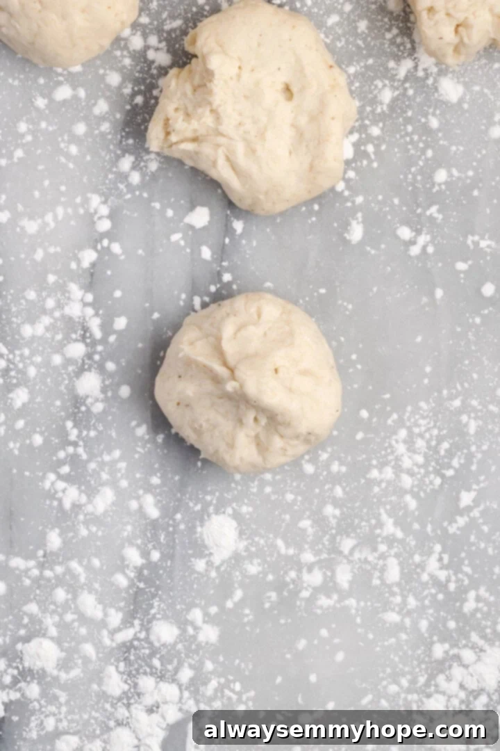Form gluten-free dough into round rolls Hands shaping individual portions of gluten-free dough into smooth round rolls