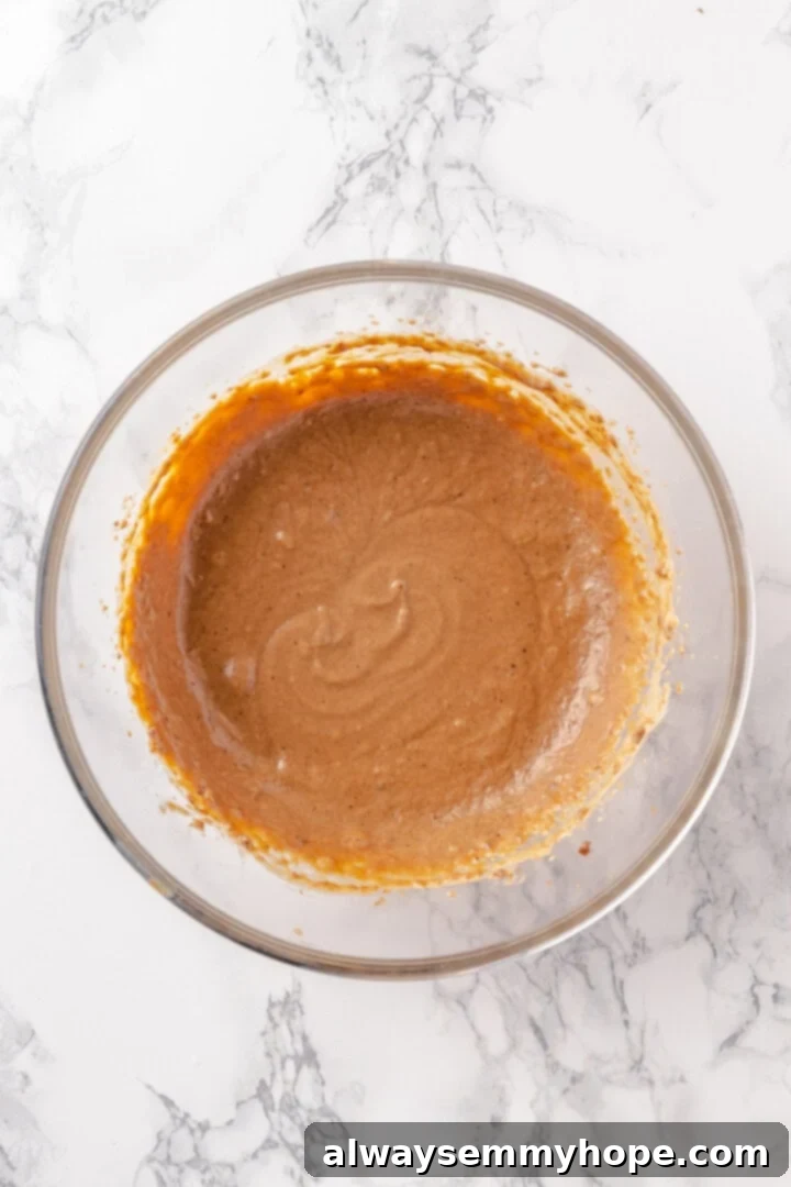 The final smooth and creamy hot buttered rum batter, perfected and ready for storage. Overhead shot of the finished creamy and smooth batter for hot buttered rum in a mixing bowl, ready for storage.
