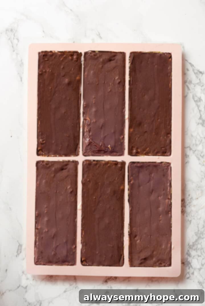 A Dubai chocolate bar is filled with crispy kataifi and a rich, creamy mixture of pistachio and tahini. Here’s how to make them at home! Overhead view of Dubai chocolate bars in molds