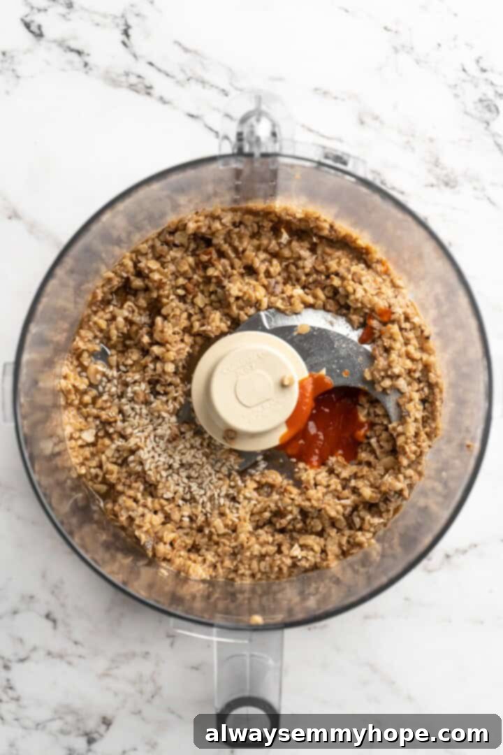 Overhead view of sauce ingredients added to walnut meat in food processor