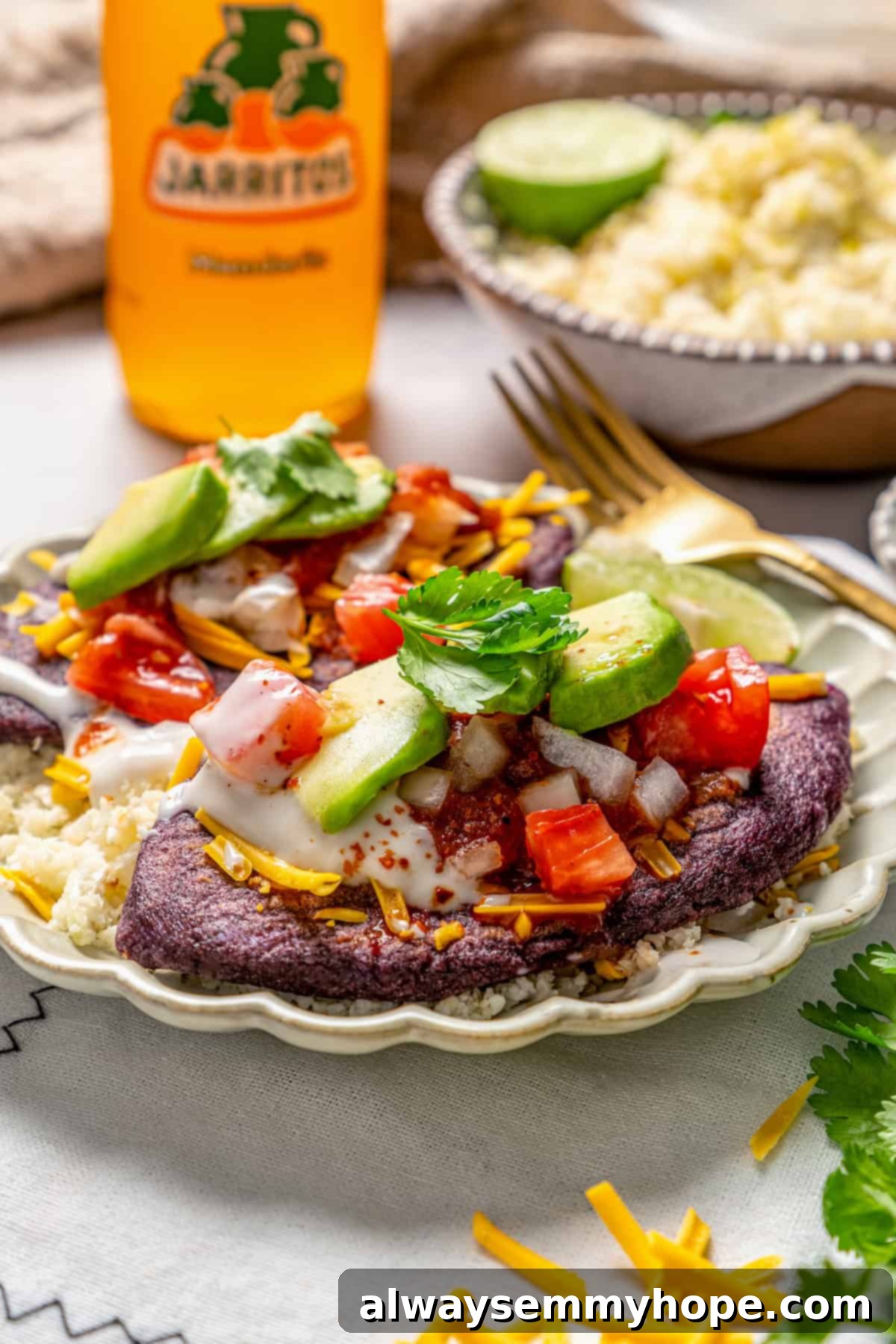 Easy tlacoyos filled with black beans. Top this homemade and vegan spin on Mexican street food with diced avocado, salsa and vegan cheese. Vegan tlacoyos on a plate with fixings.