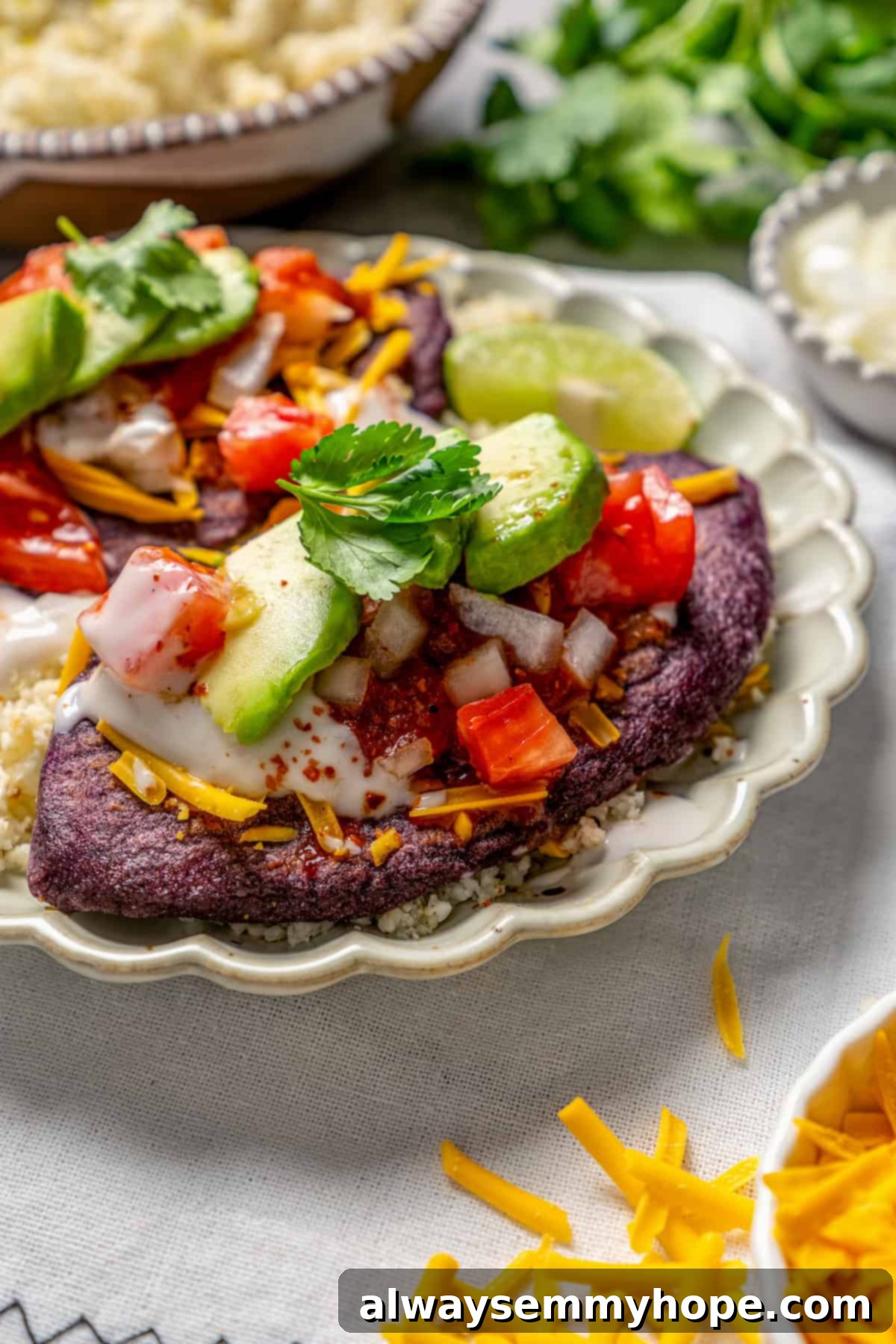 Easy tlacoyos filled with black beans. Top this homemade and vegan spin on Mexican street food with diced avocado, salsa and vegan cheese. Tlacoyo on a plate with toppings.