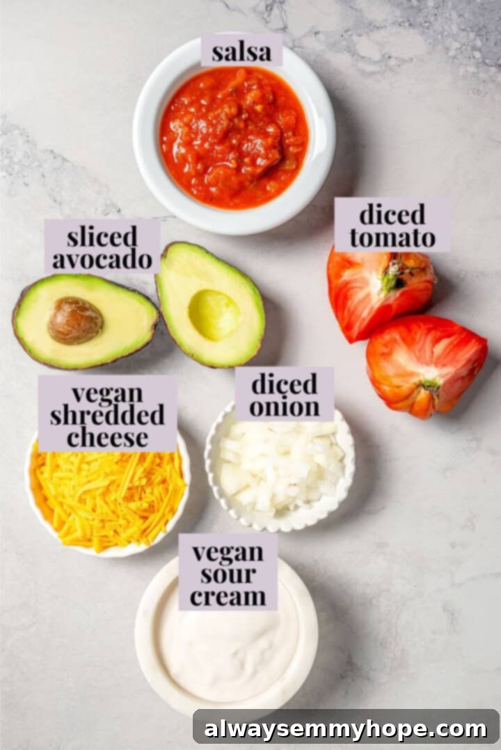 Easy tlacoyos filled with black beans. Top this homemade and vegan spin on Mexican street food with diced avocado, salsa and vegan cheese. Ingredients for tlacoyos on a marble countertop.