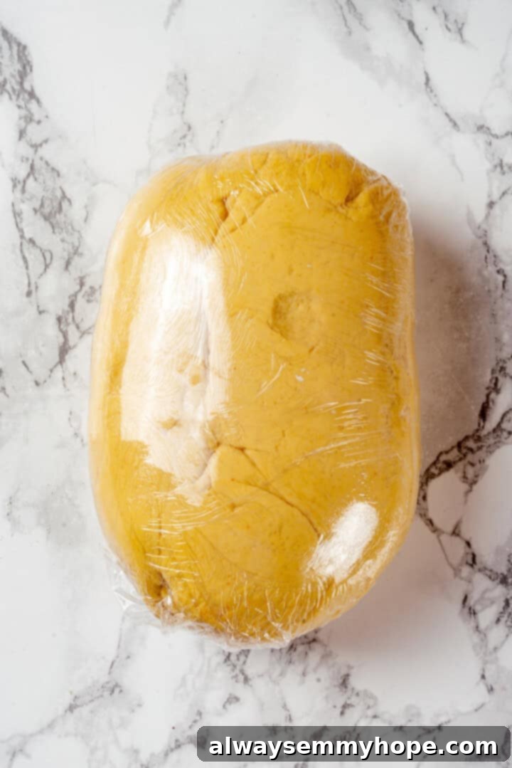 This vegan timpano recipe is perfect for the holidays! It’s loaded with pasta, veggies and plant-based cheese, all baked in a pastry crust. Freshly prepared dough for timpano, wrapped tightly in plastic wrap, resting before use.