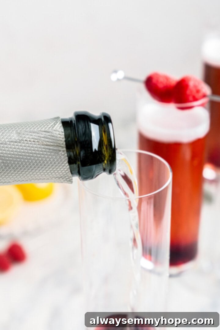 Sparkling wine being gently poured into a champagne flute already containing crème de cassis, creating a beautiful color blend.
