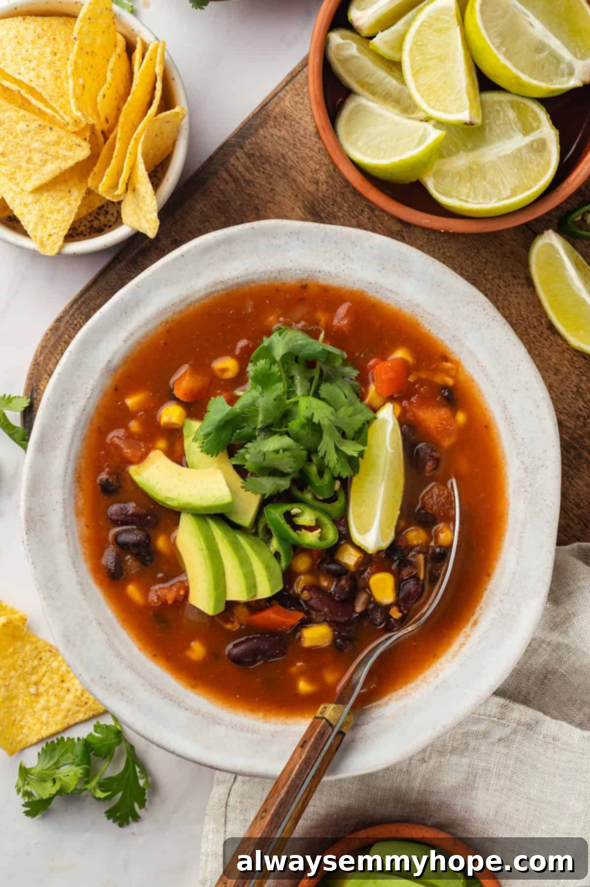 This vegan taco soup packs in a whole lot of flavour! With a zesty broth, lots of beans, and veggies, this soup is hearty and satisfying. Overhead view of vegan taco soup in bowl