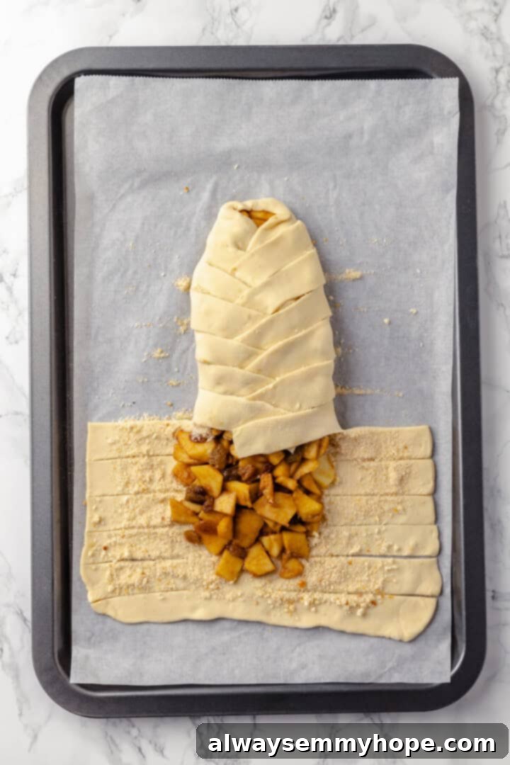 This easy apple strudel recipe wraps tender cinnamon-spiced apples in flaky puff pastry for a cozy treat. It's always a hit! Overhead view of apple strudel being braided