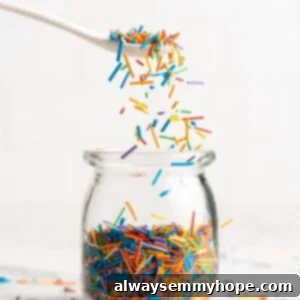 Spoonful of homemade sprinkles held over jar