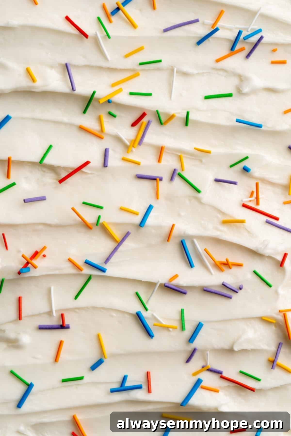 A close-up of a frosted cupcake adorned with a generous amount of freshly made, multicolored homemade sprinkles.