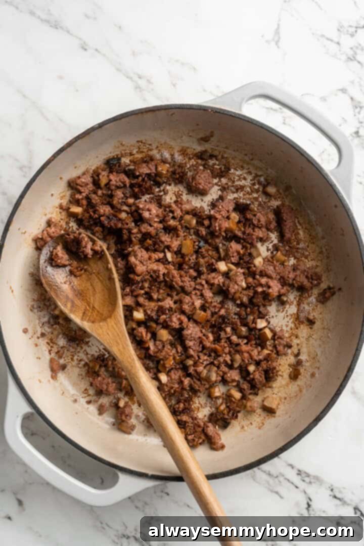 Stir-frying vegan meat and mushrooms for Mapo Tofu Vegan meat substitute and diced mushrooms cooking in a hot skillet, browning beautifully.