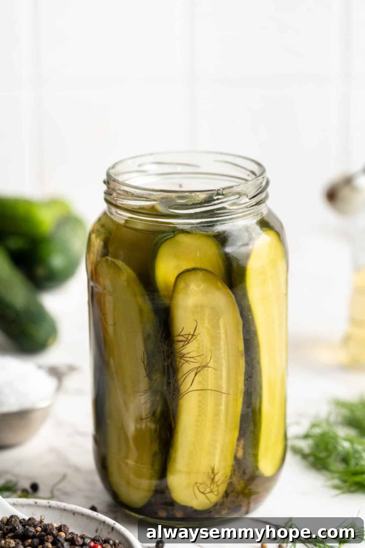 Close-up of a jar of homemade pickles, showing the vibrant green cucumbers and clarity of the brine.