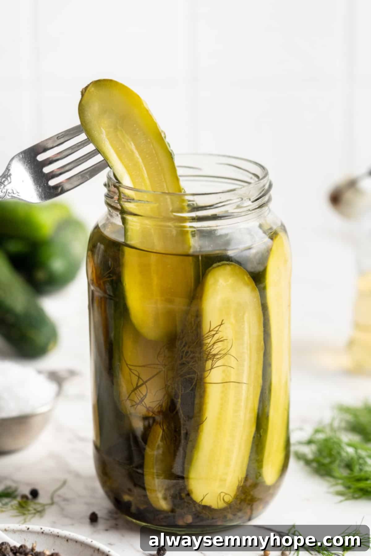 A fork reaching into a jar to retrieve a homemade pickle, highlighting its freshness.