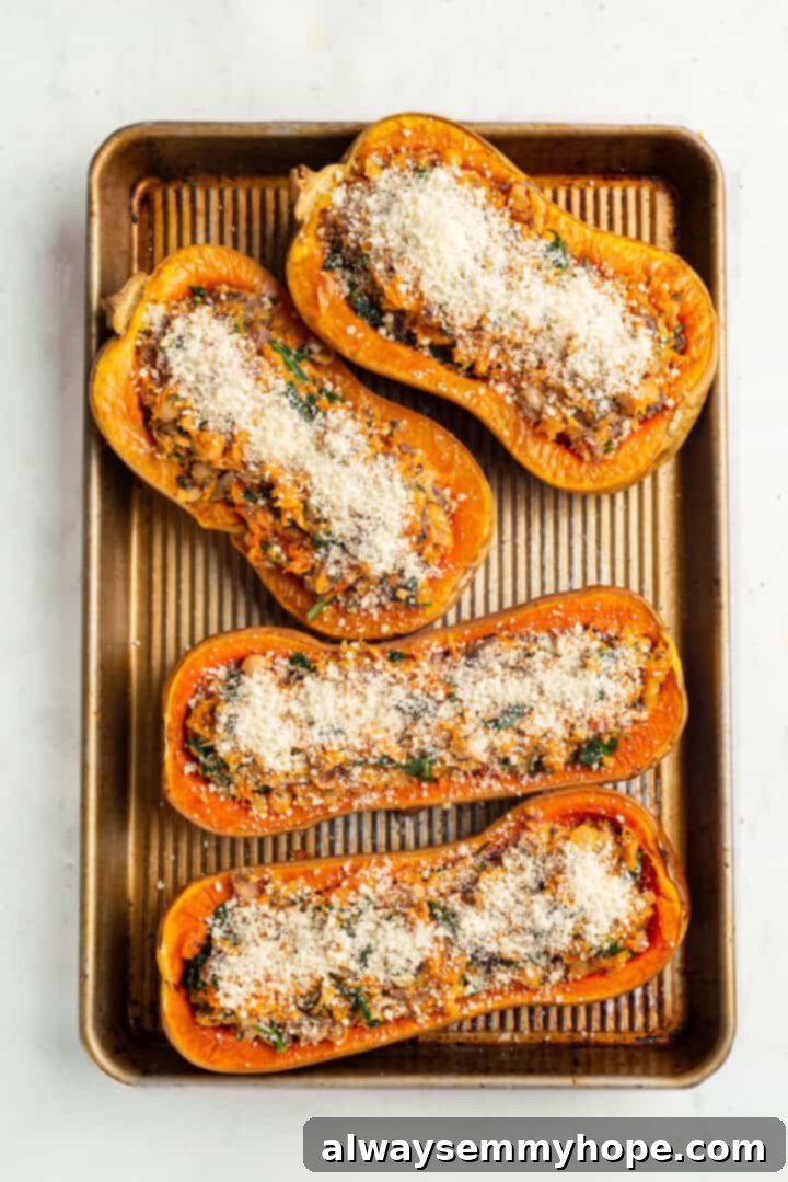 Stuffed butternut squash on pan with vegan parmesan sprinkled on top