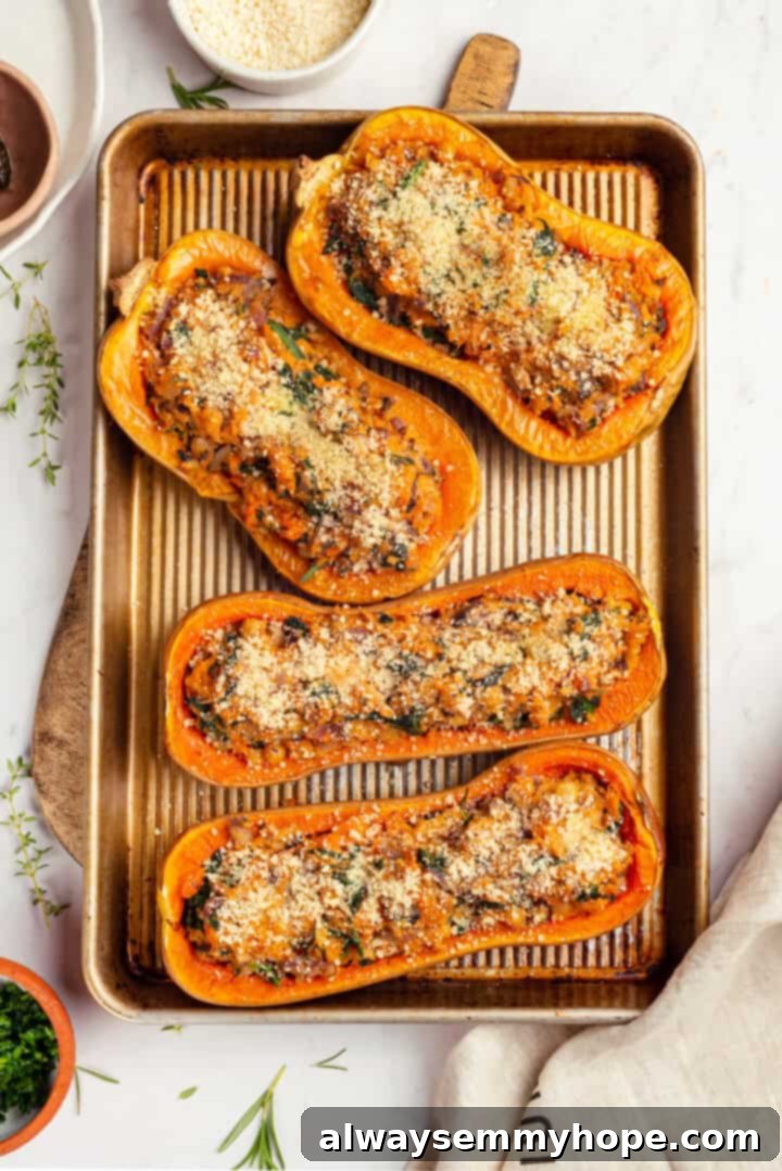 Overhead view of 4 stuffed butternut squash halves on a sheet pan, baked until golden