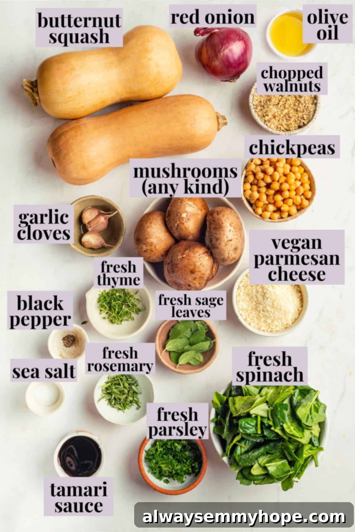 Overhead view of all the fresh ingredients for stuffed butternut squash arranged on a white surface
