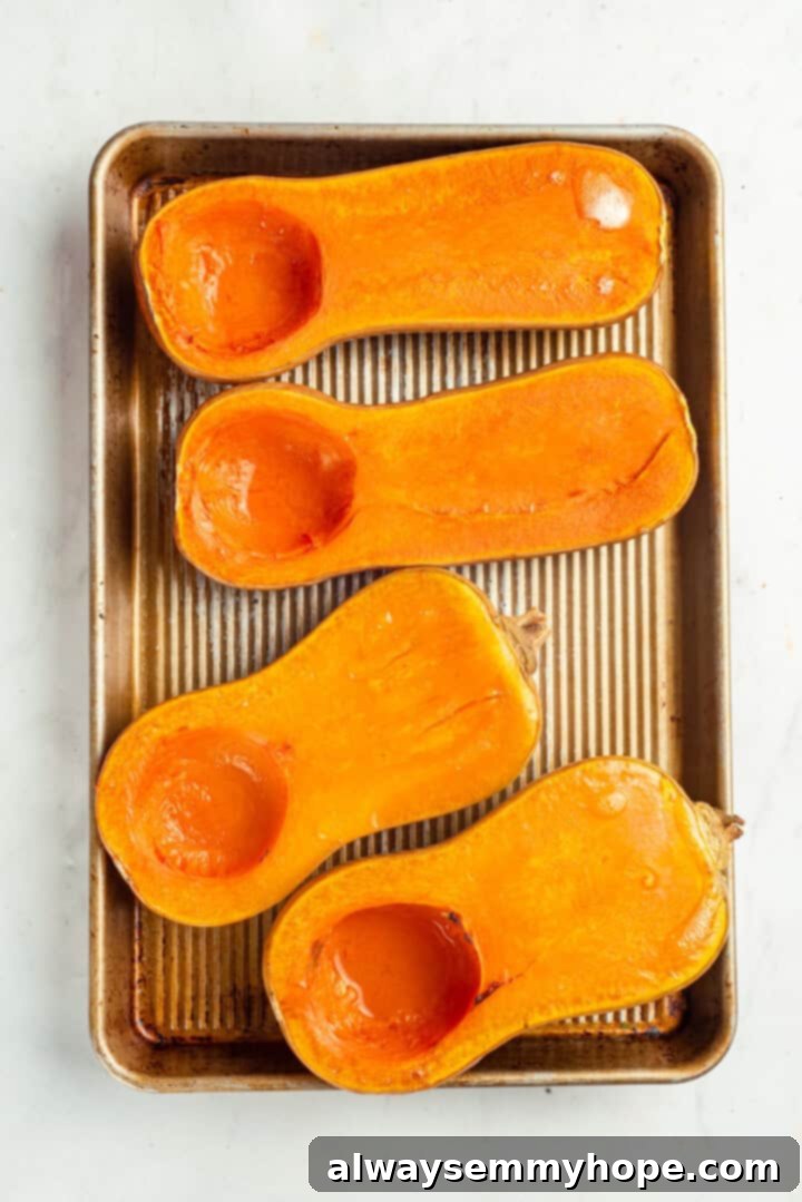 Roasted butternut squash halves on baking sheet