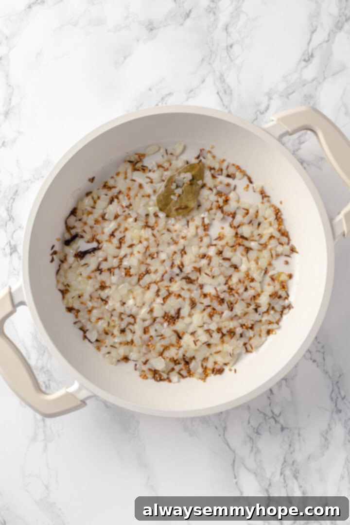 Vegetable korma is a rich and creamy Indian curry loaded with warm spices and tender veggies. It’s absolutely decadent and so easy to make! Onions, cloves, bay leaf, mustard, and cumin seeds cooking in pot