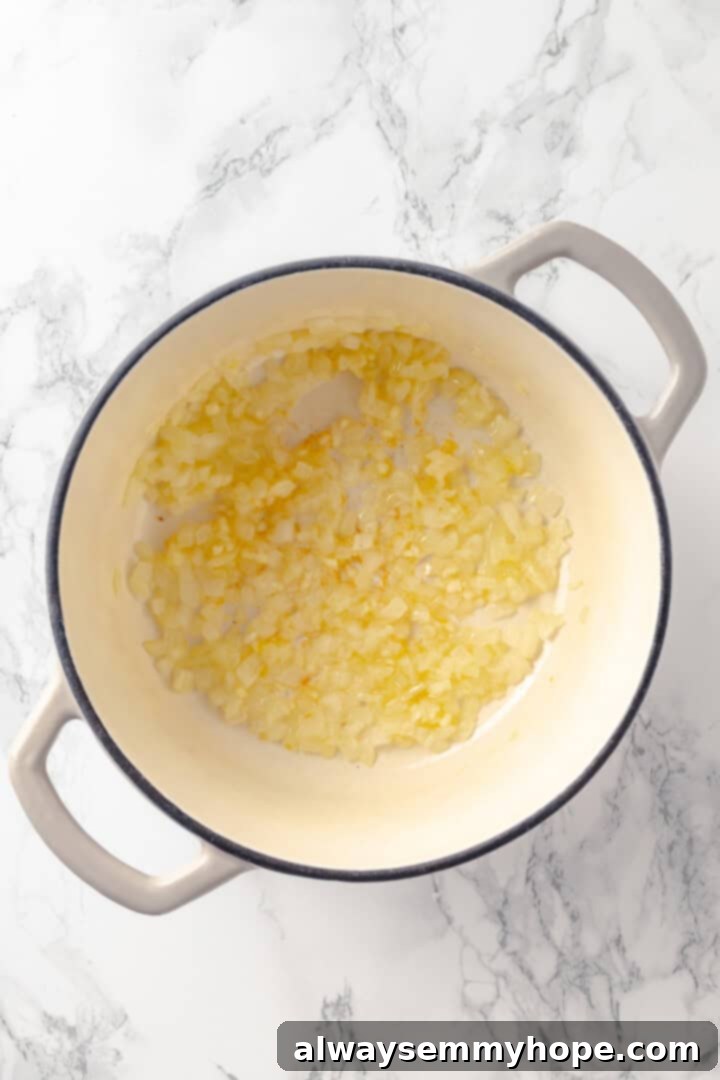 Onions glistening in olive oil, gently sautéing in a large pot, forming the aromatic base of the split pea soup.