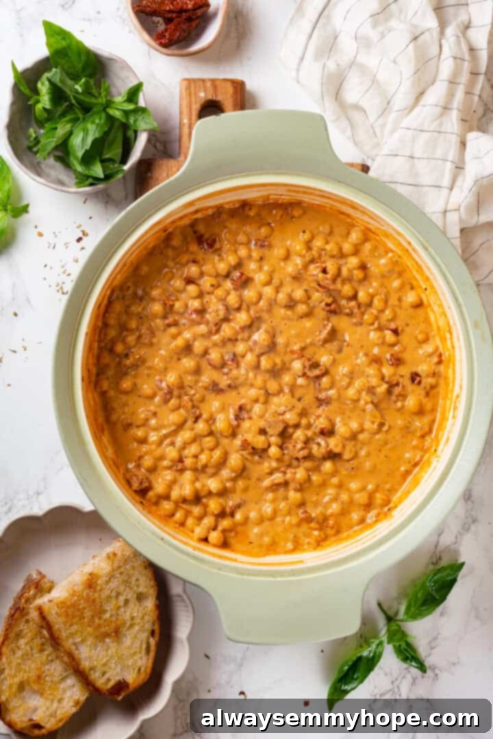 Marry Me Chickpeas simmering gently in a pan, the rich, creamy sauce coating every chickpea, ready to be served.