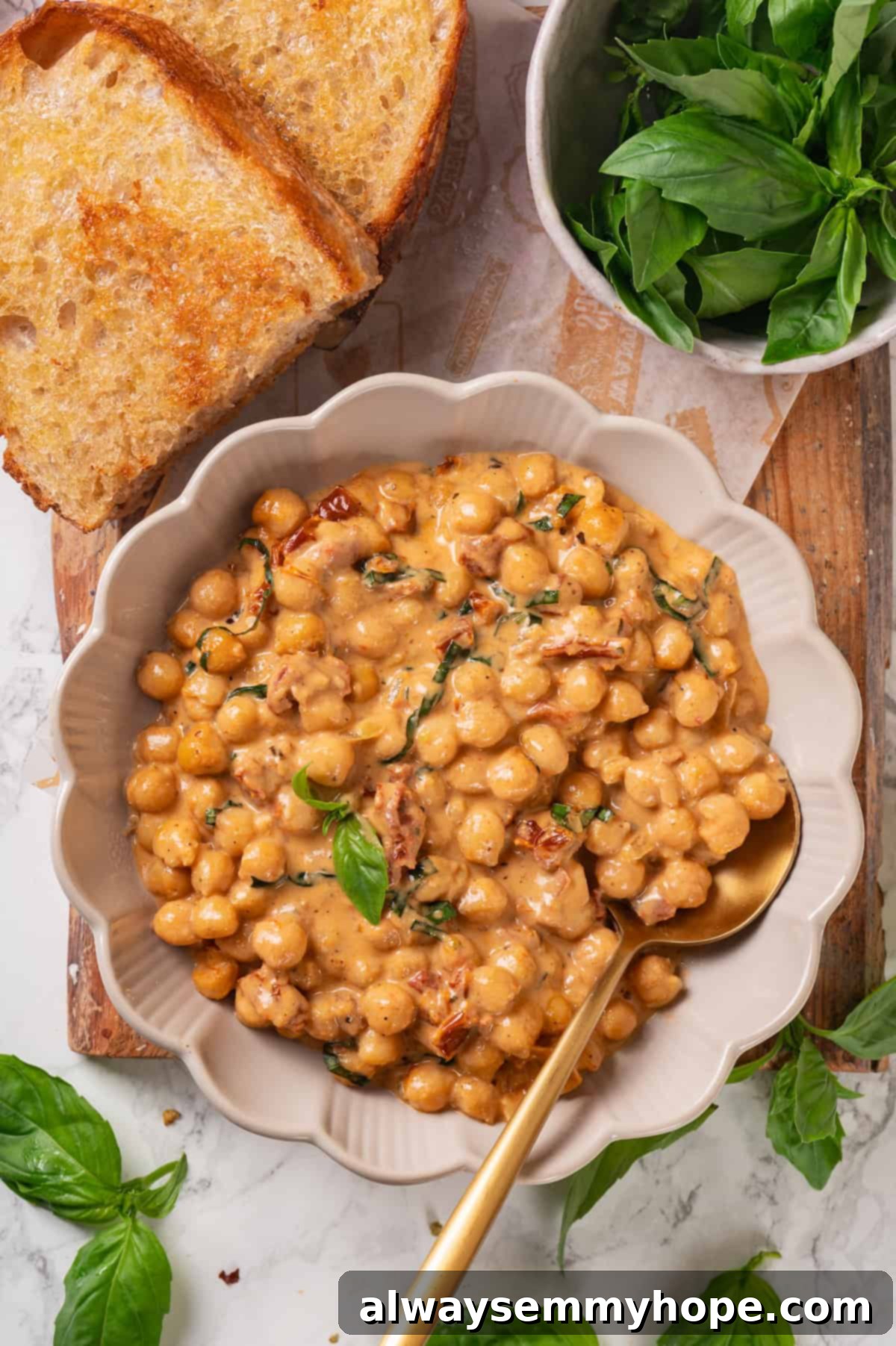 Overhead shot of Marry Me Chickpeas served in a rustic bowl, garnished with fresh basil, ready to be enjoyed.