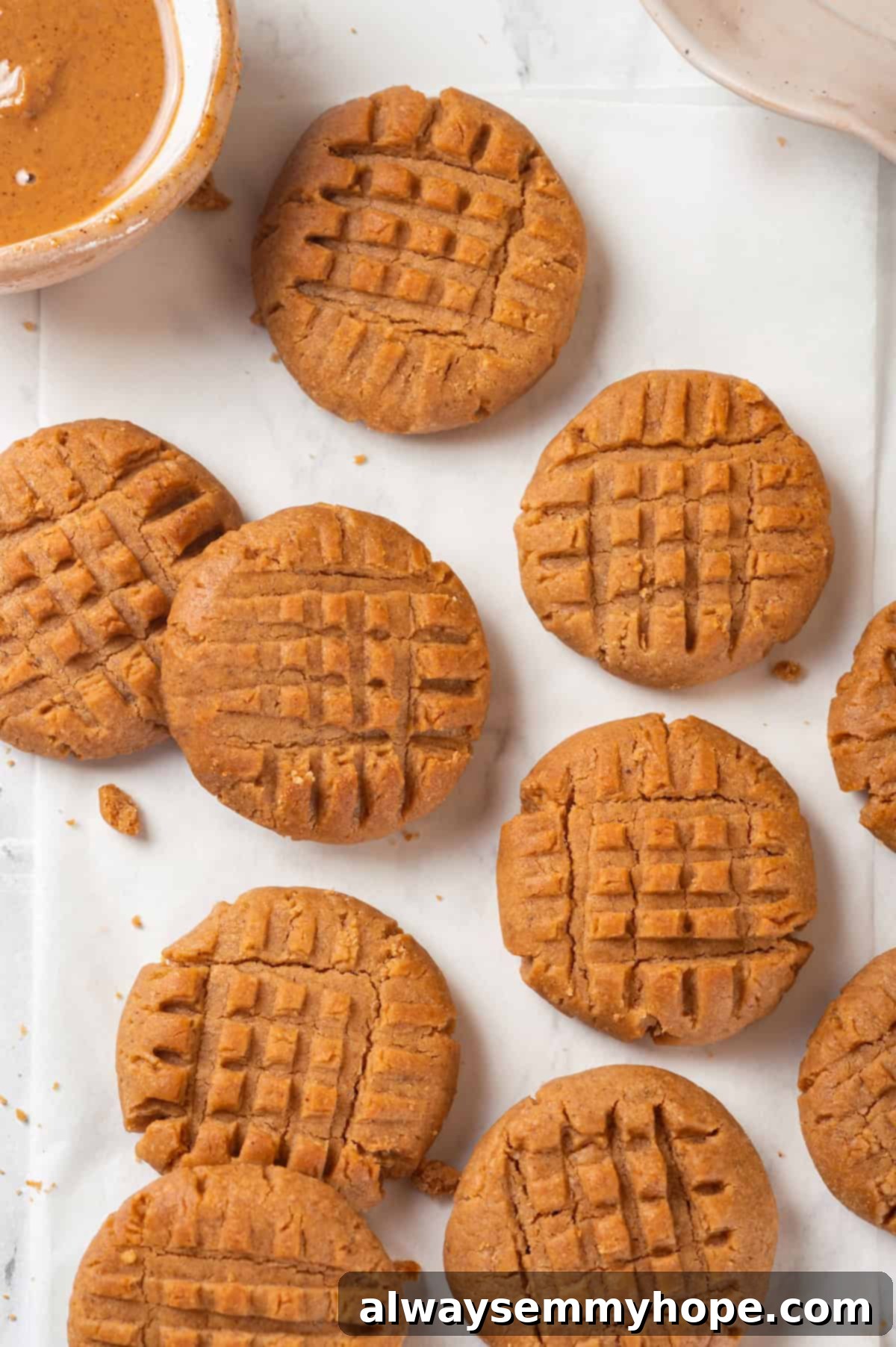 Overhead view of multiple fresh vegan peanut butter cookies arranged on a wooden countertop
