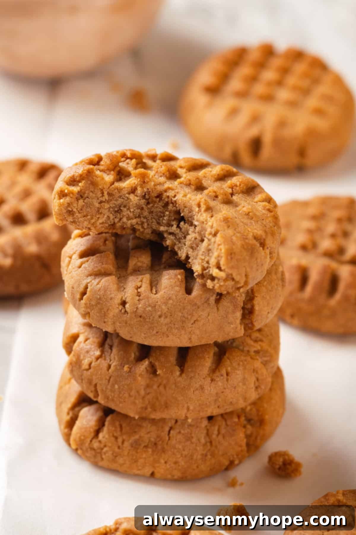 Stack of three vegan peanut butter cookies, with the top cookie having a bite taken out of it