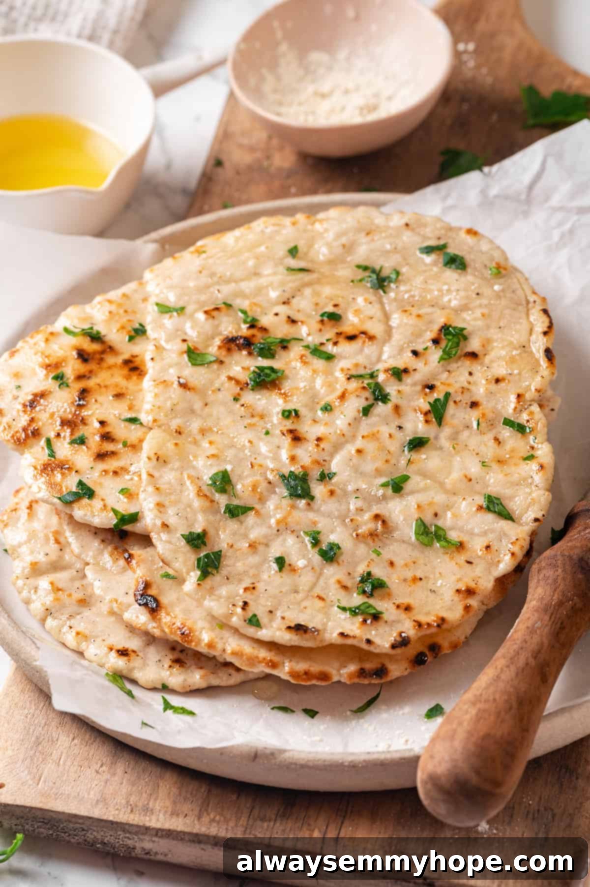 This easy gluten-free naan recipe has the chewy texture and slightly charred bits that make naan so irresistible, but without the wheat! A stack of perfectly cooked gluten-free naan on a plate, ready to be served, highlighting its appealing texture.