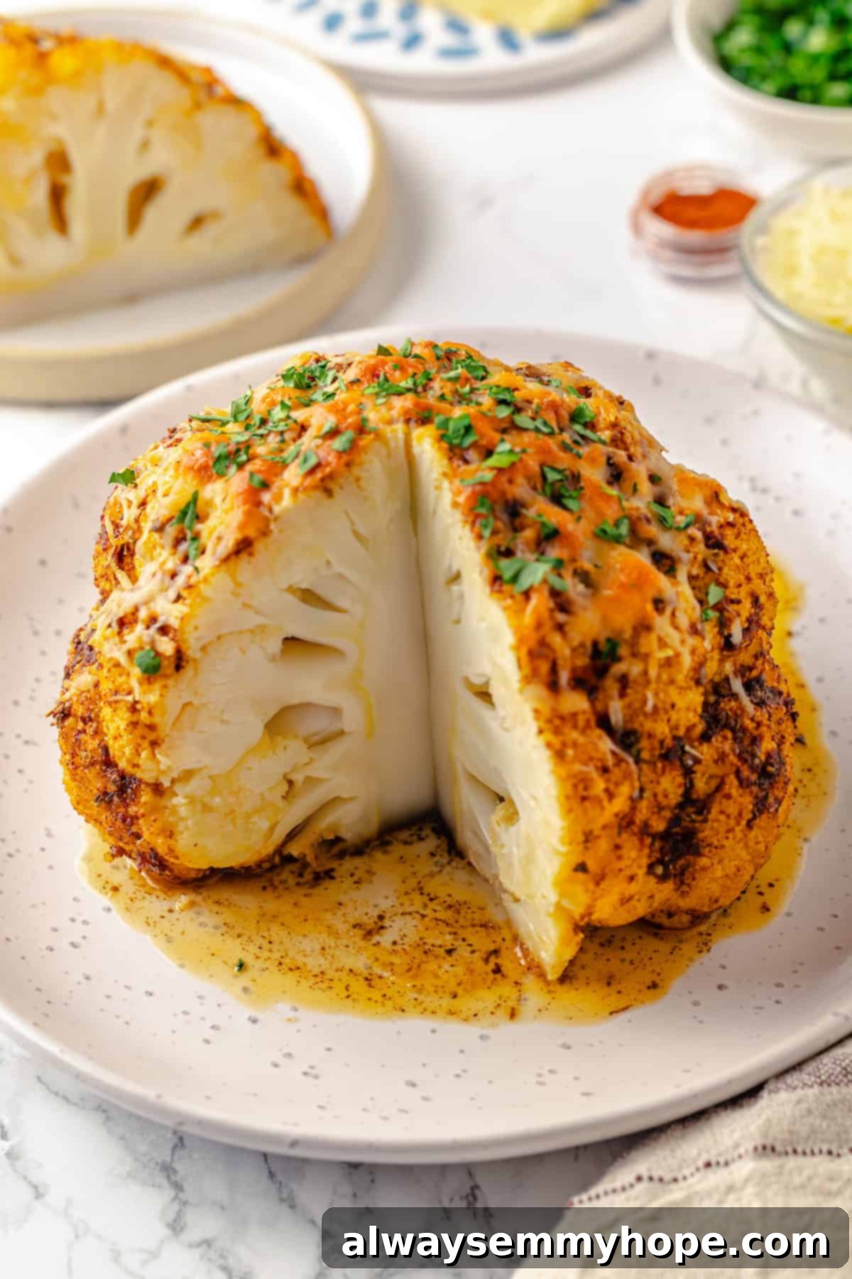 A close-up of a perfectly roasted whole cauliflower, golden and tender, with a wedge removed, highlighting its beautiful texture.