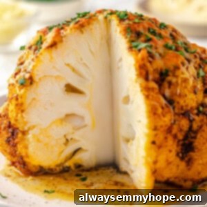 Whole roasted cauliflower on platter with wedge cut to show inside