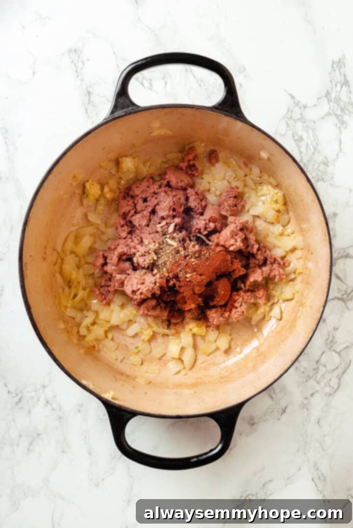 Zuppa toscana is creamy and hearty with tender potatoes and kale, and this vegan version is just as tasty as the Olive Garden original! Seasonings and vegan sausage added to pot of sauteed onions.