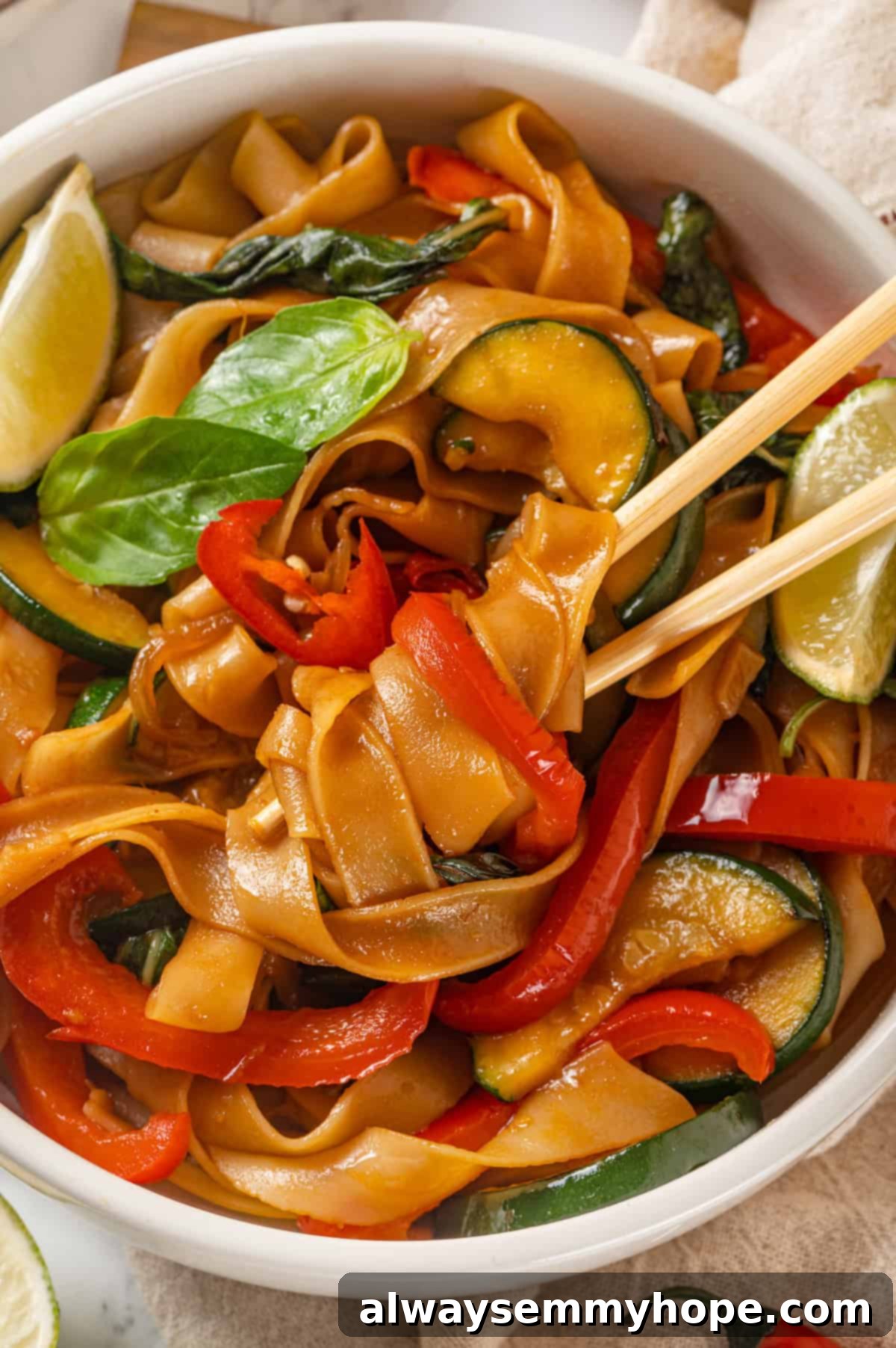 This easy Thai drunken noodles recipe is a quick stir-fry dinner perfect for a weeknight. They're sweet, savoury, spicy—and vegan too! Chopsticks in bowl of drunken noodles