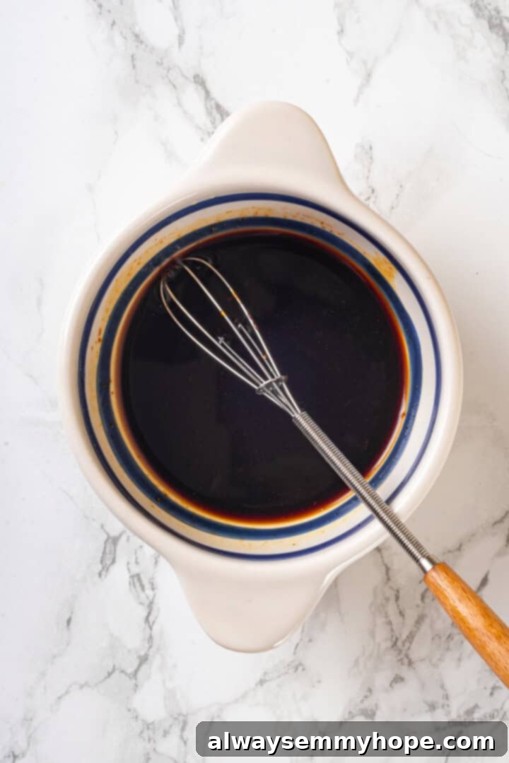 This easy Thai drunken noodles recipe is a quick stir-fry dinner perfect for a weeknight. They're sweet, savoury, spicy—and vegan too! Sauce for drunken noodles in bowl with whisk