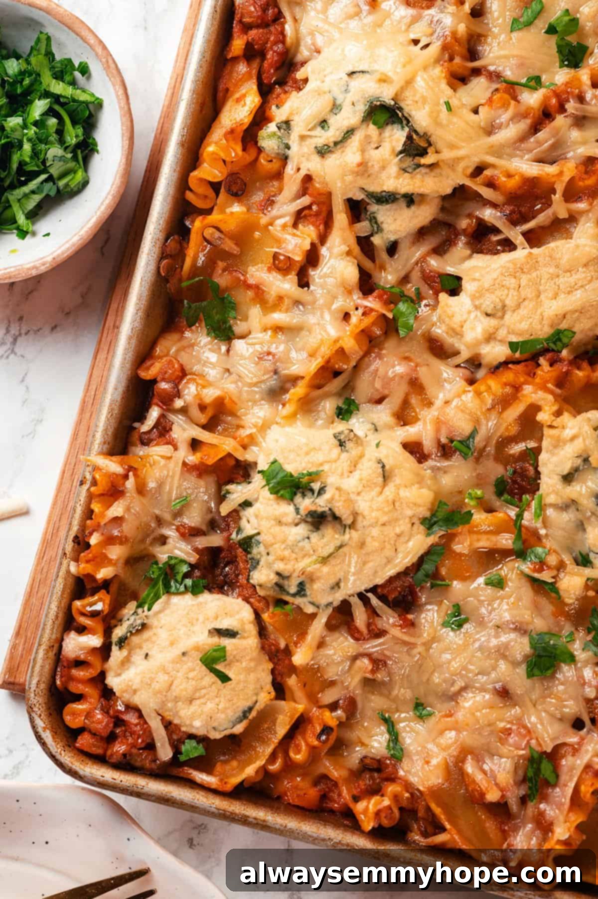 This vegan sheet pan lasagna recipe is a different way to enjoy all that cheesy pasta goodness—easier, quicker, and more crispy edges! Overhead view of vegan sheet pan lasagna in pan