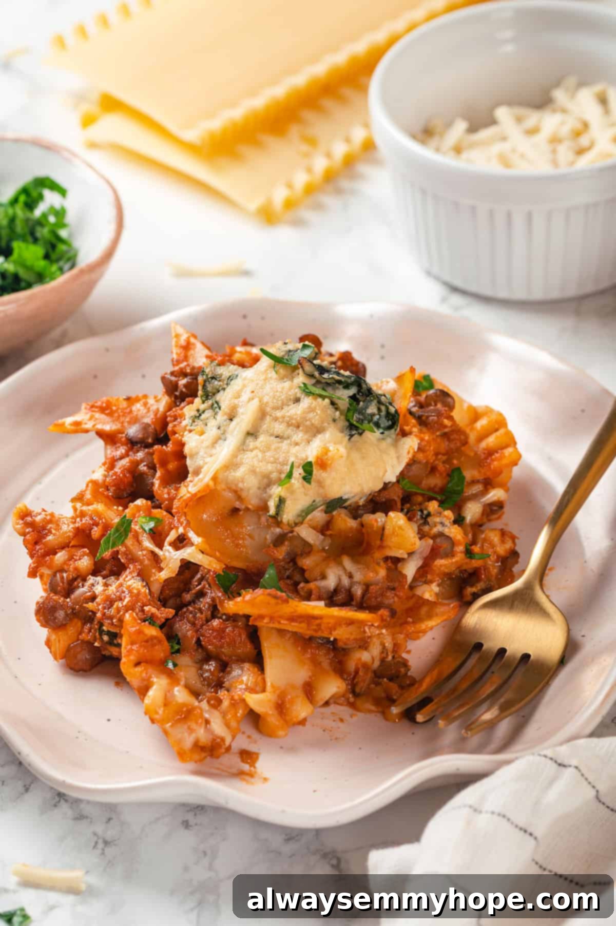 This vegan sheet pan lasagna recipe is a different way to enjoy all that cheesy pasta goodness—easier, quicker, and more crispy edges! Vegan sheet pan lasagna on plate with fork