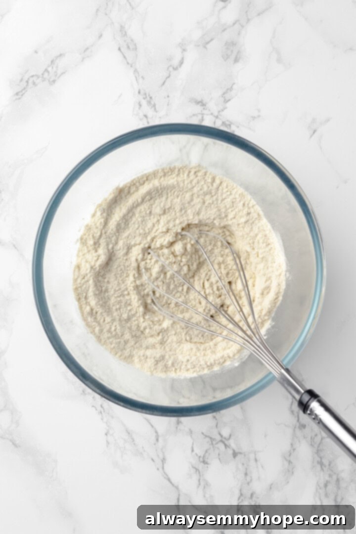 Dry ingredients including flour, baking powder, cinnamon, and salt in a separate mixing bowl with a whisk