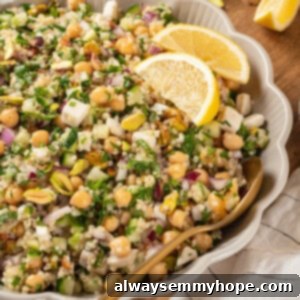 Jennifer Aniston salad in serving bowl with lemon wedges