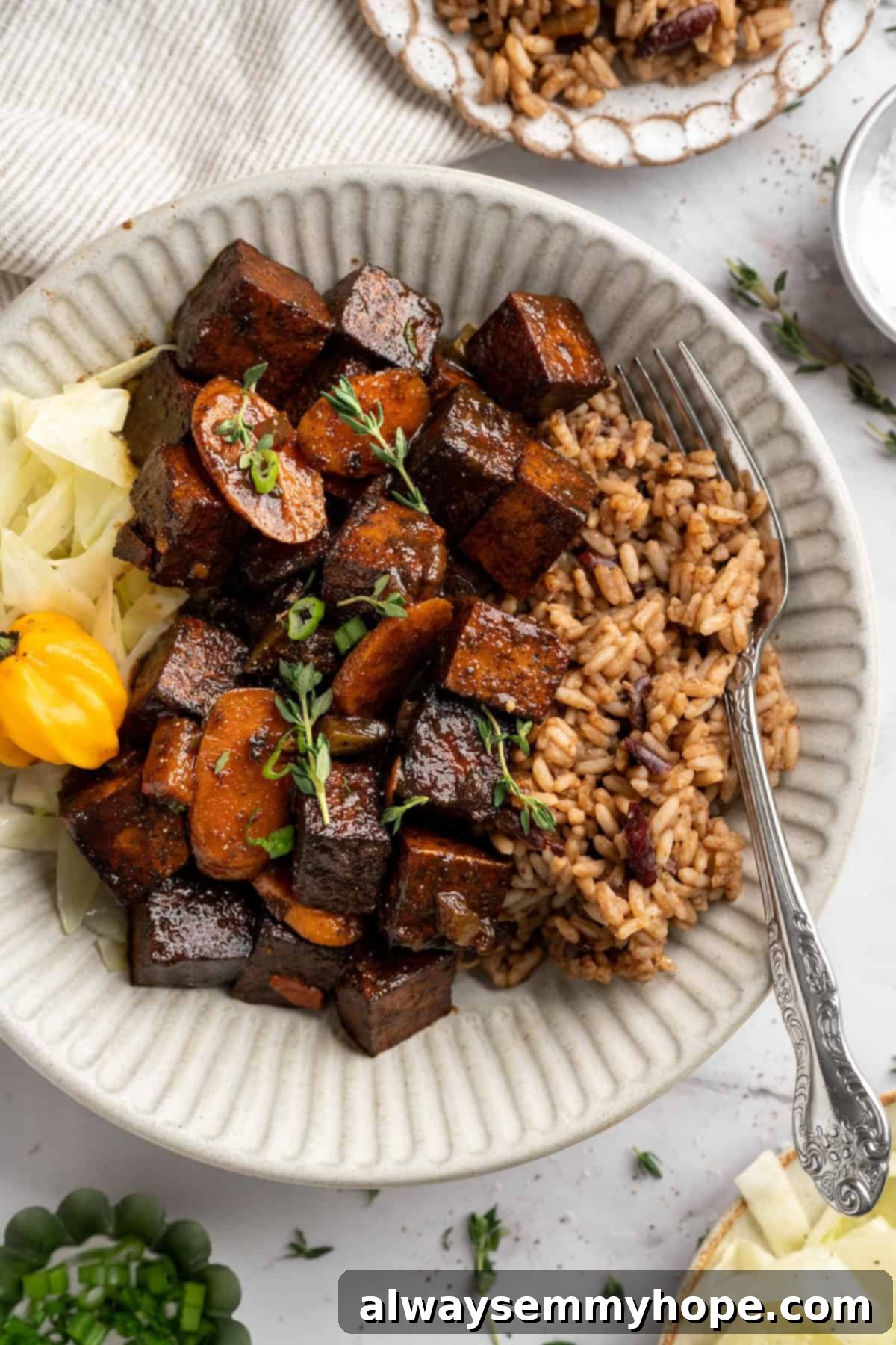 This brown stew tofu recipe is a flavourful, hearty dinner inspired by traditional Jamaican cooking—but with a vegan twist! Bowl of brown stew tofu with rice, ready to be served