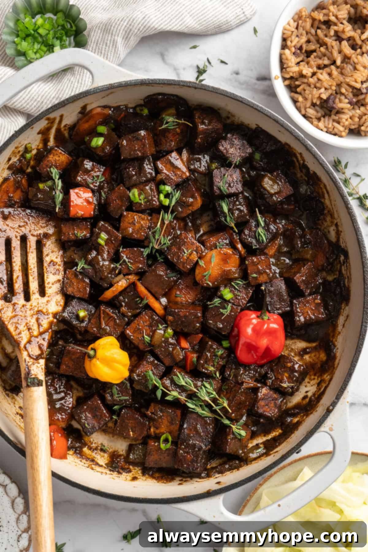 This brown stew tofu recipe is a flavourful, hearty dinner inspired by traditional Jamaican cooking—but with a vegan twist! Brown stew tofu simmering in a cast iron skillet, with vegetables and a rich sauce