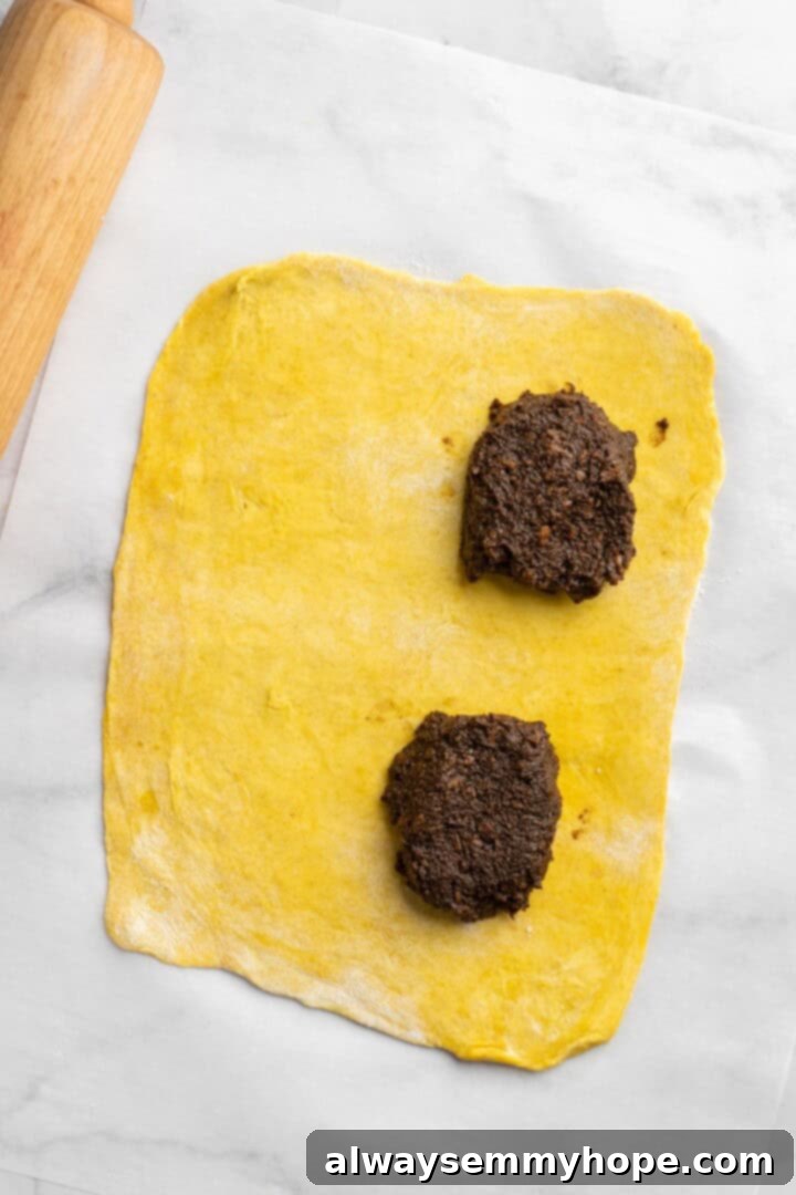 Filling added to dough for vegan Jamaican patties, ready for folding