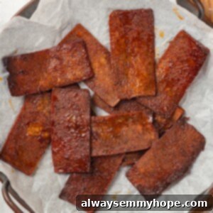 Delicious Tofu Bacon Recipe Card Image Overhead view of crispy tofu bacon on parchment paper