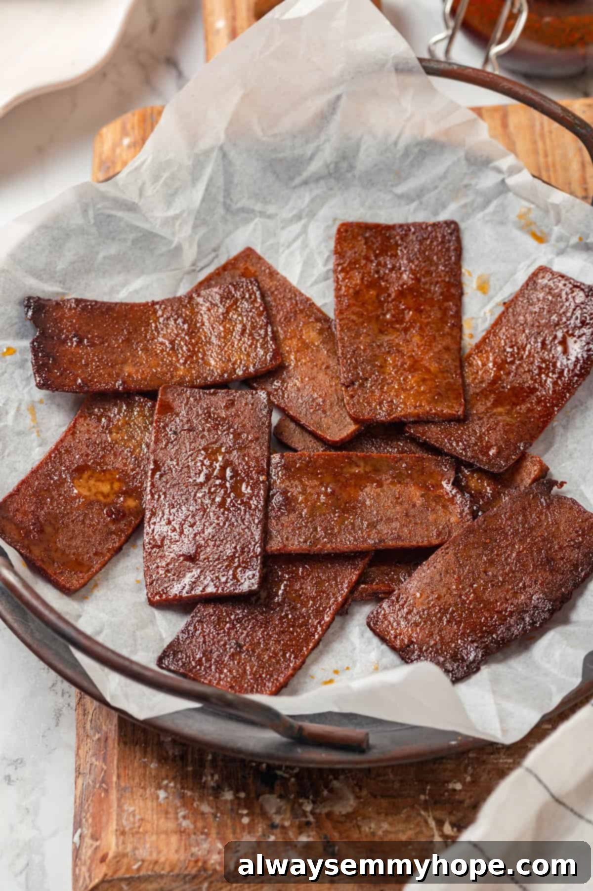 Perfectly Crispy Tofu Bacon Strips Crispy, golden-brown vegan tofu bacon strips laid out on parchment paper on a baking sheet, showcasing their perfectly cooked texture.