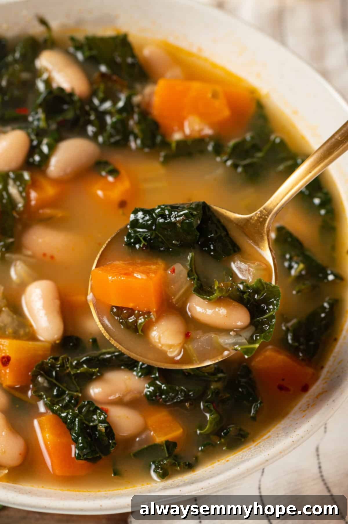 Spoonful of kale soup held over bowl