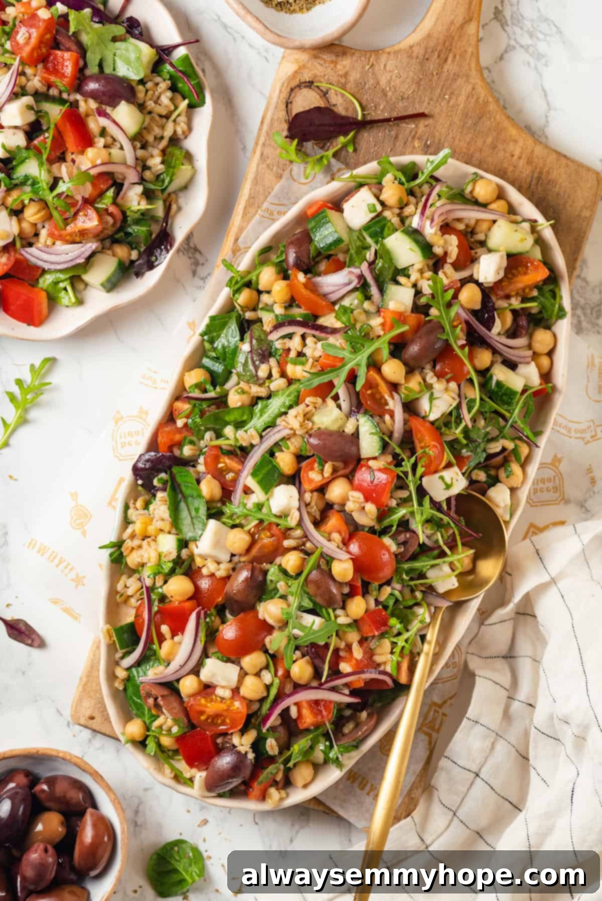 This farro salad is hearty and satisfying, with bright and bold Greek flavours to make it delicious. It might just be the perfect lunch! Large platter of Greek farro salad, elegantly arranged and garnished, ready to be served