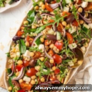 Mediterranean Farro Salad 2 Top-down view of farro salad with vegetables, chickpeas, and greens