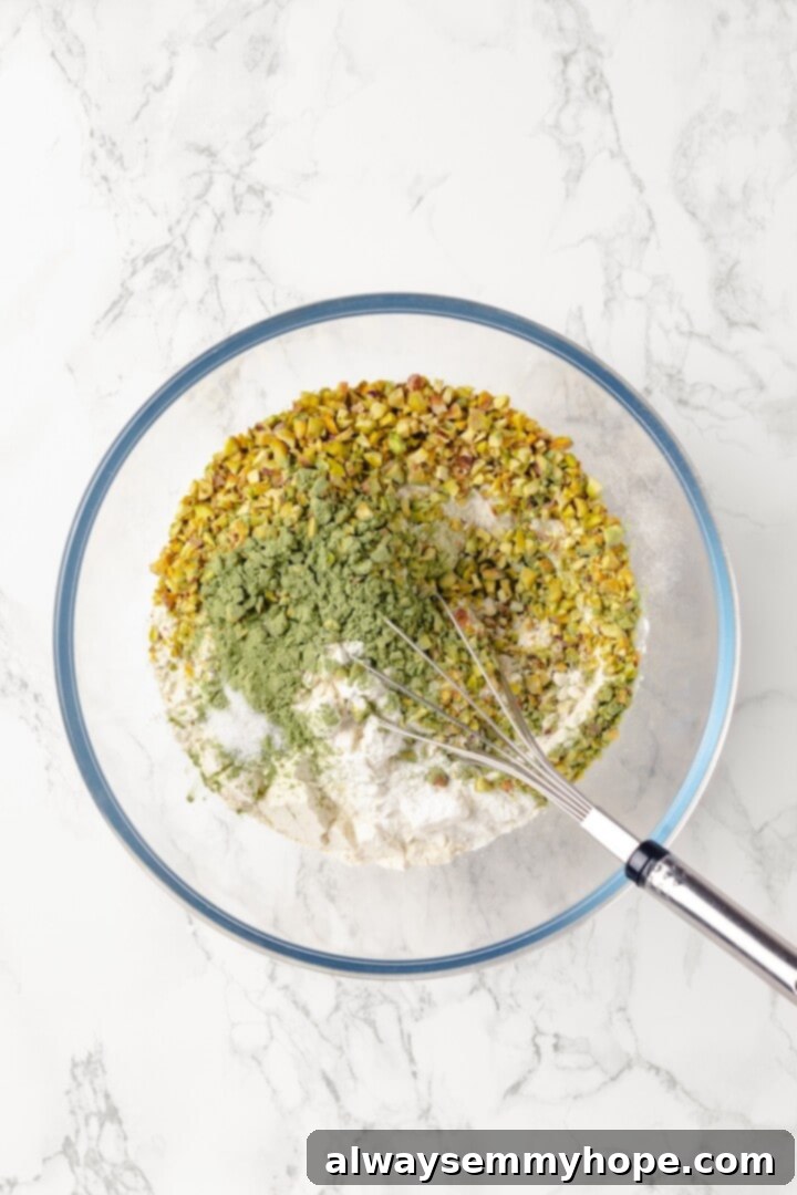 Overhead view of dry ingredients for pistachio cake in bowl before whisking