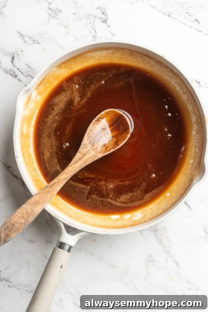 Overhead view of finished, thickened date syrup in a saucepan, rich and dark, ready to be cooled
